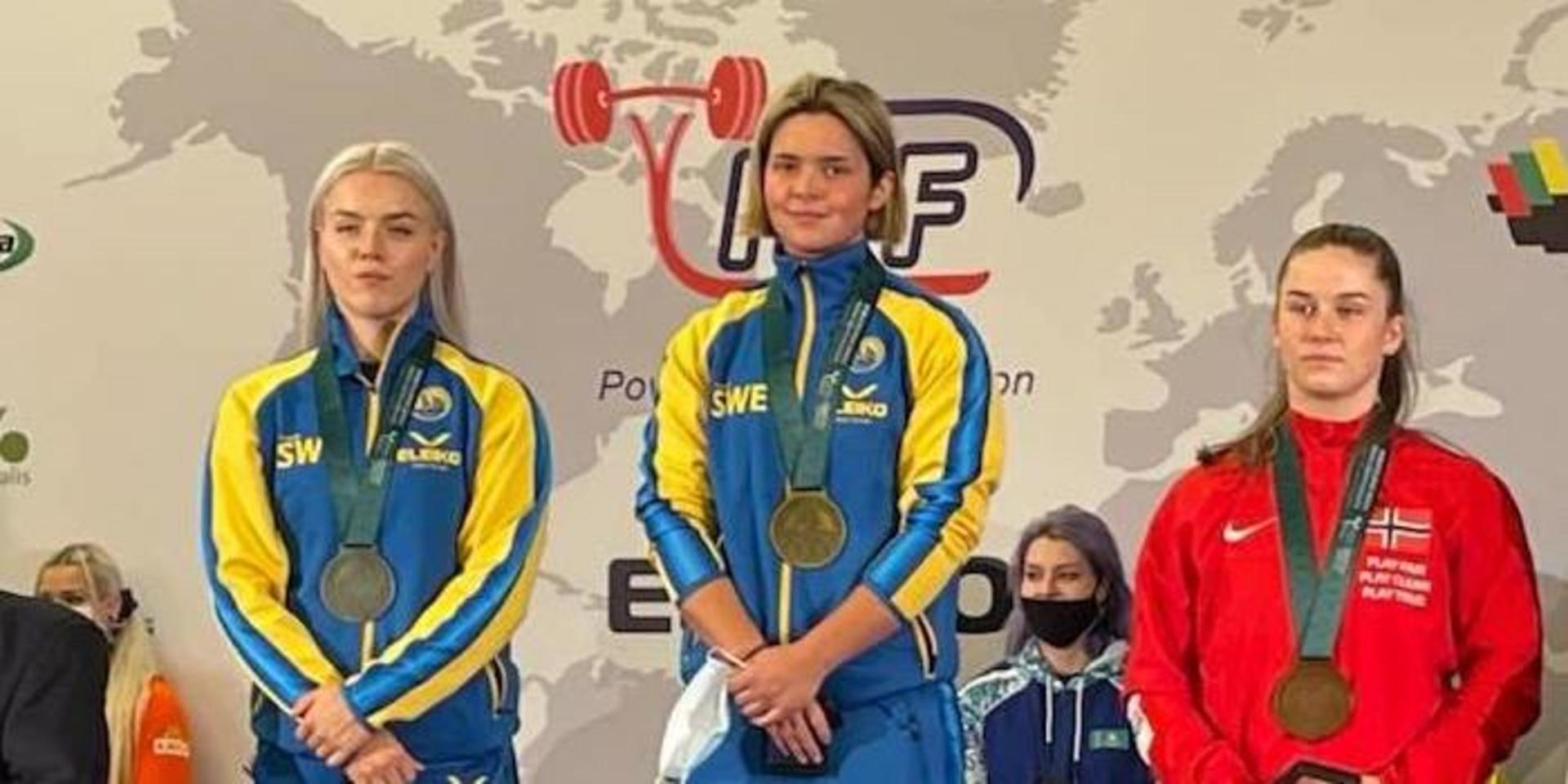 Elsa Marin Karlsson från Svanesund på Orust högst upp på prispallen. Till vänster står tvåan Agnes Rudin. Elsa vann med vikten 117,5 kilo men tror sig ha kunnat klara tio kilo till.
