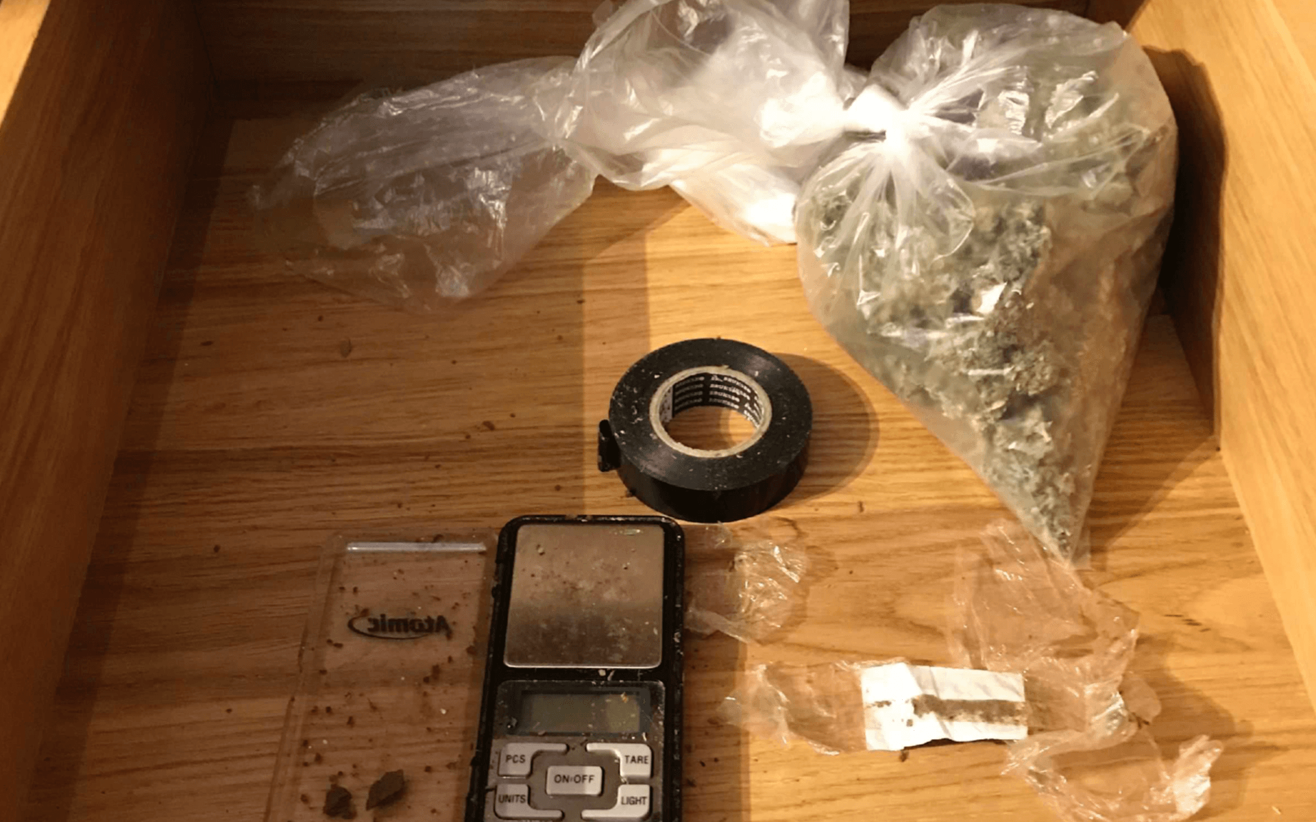 Lådan polisen fann visade sig innehålla bland annat en våg med rester av cannabis på. Lådan innehöll också en lite större påse med marijuana och pressad kokain.