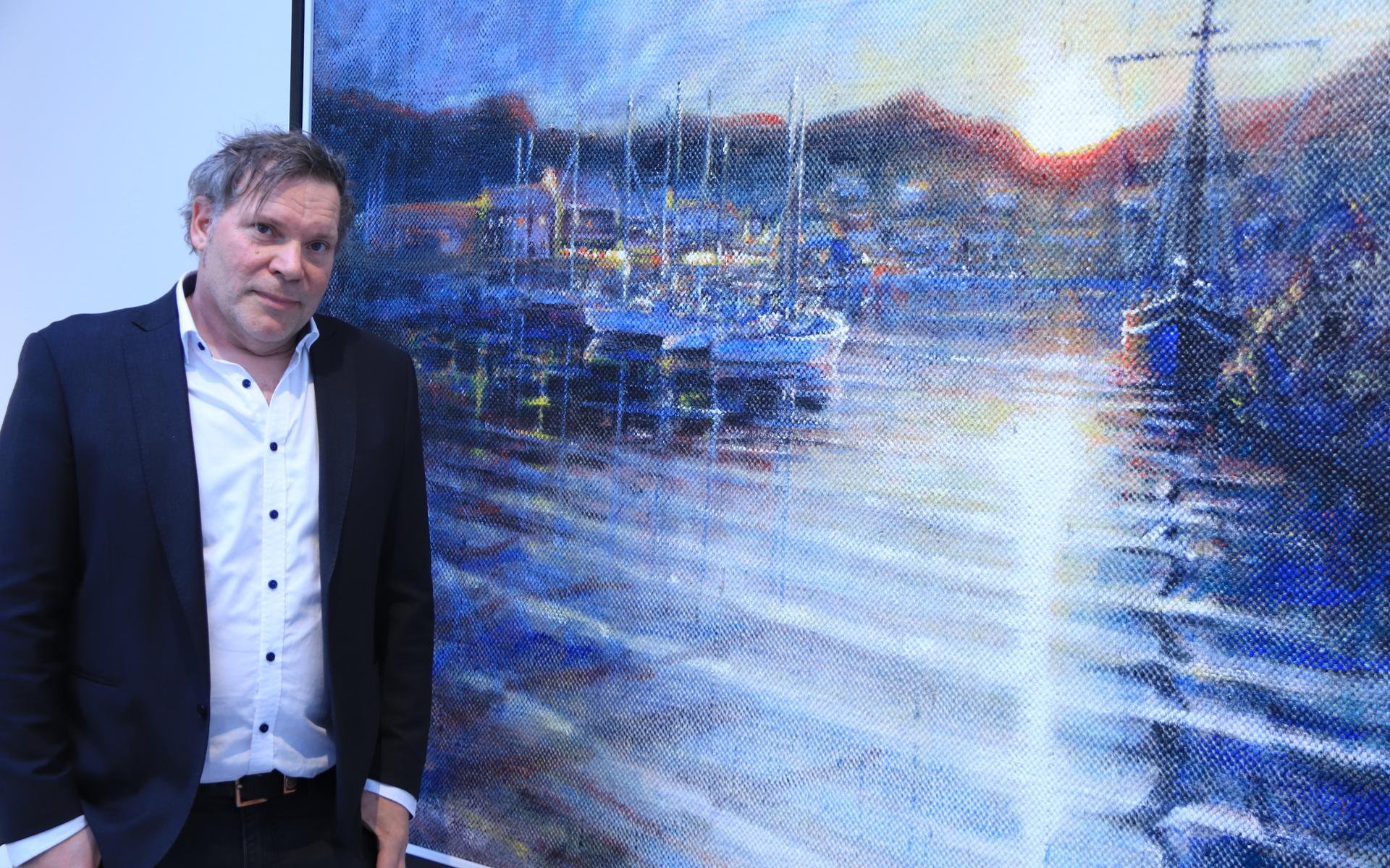 John Lundqvist med ett västkustmotiv som han målat på trasmatta.