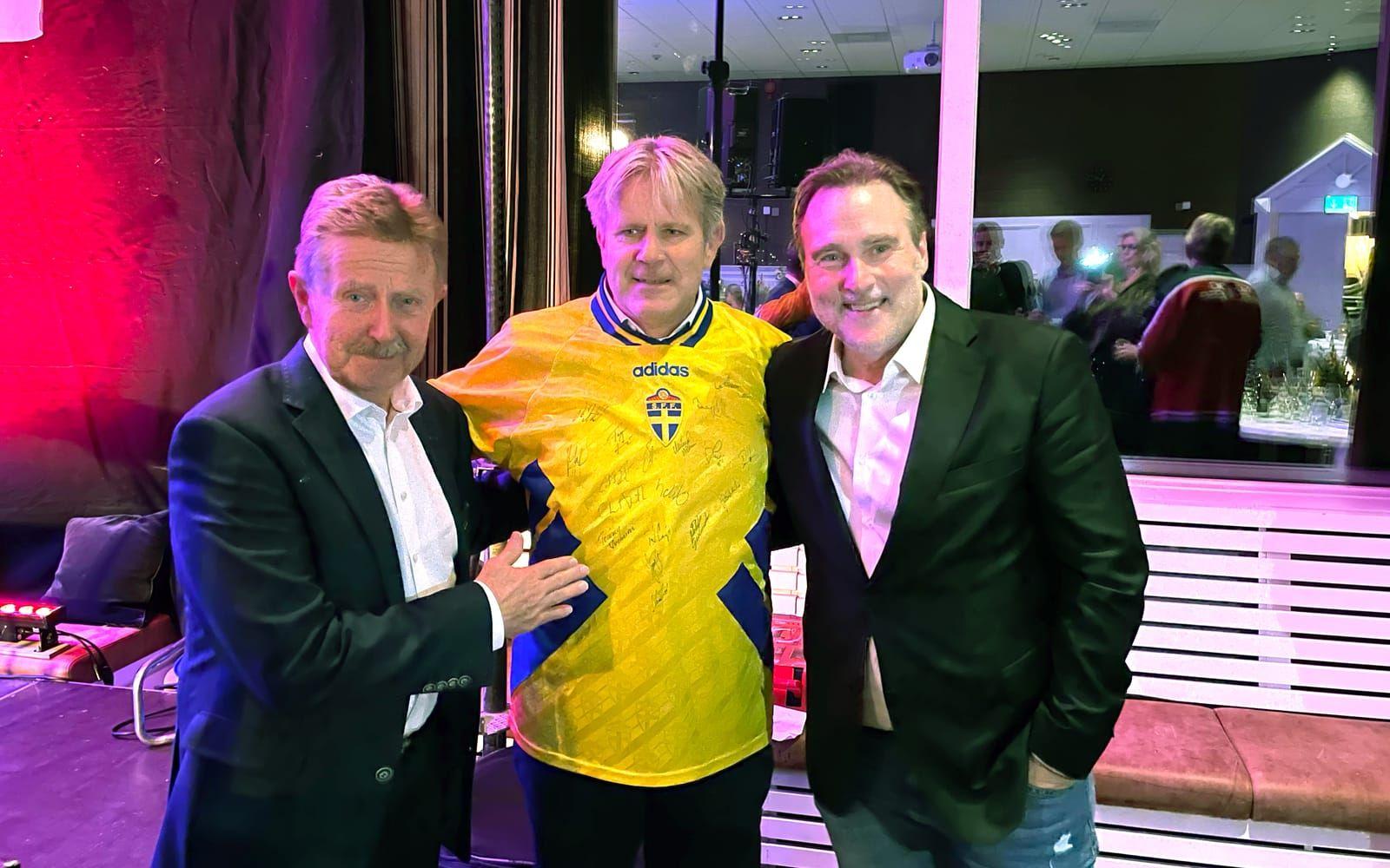 Thomas Andersson budade hem en landslagströja från 1994, signerad av det bronsvinnande svenska VM-laget i fotboll, till sina företag. Här syns han flankerad av TV-sportprofilen Staffan Lindeborg och Staffan Oldsberg, son till Ingvar Oldsberg.