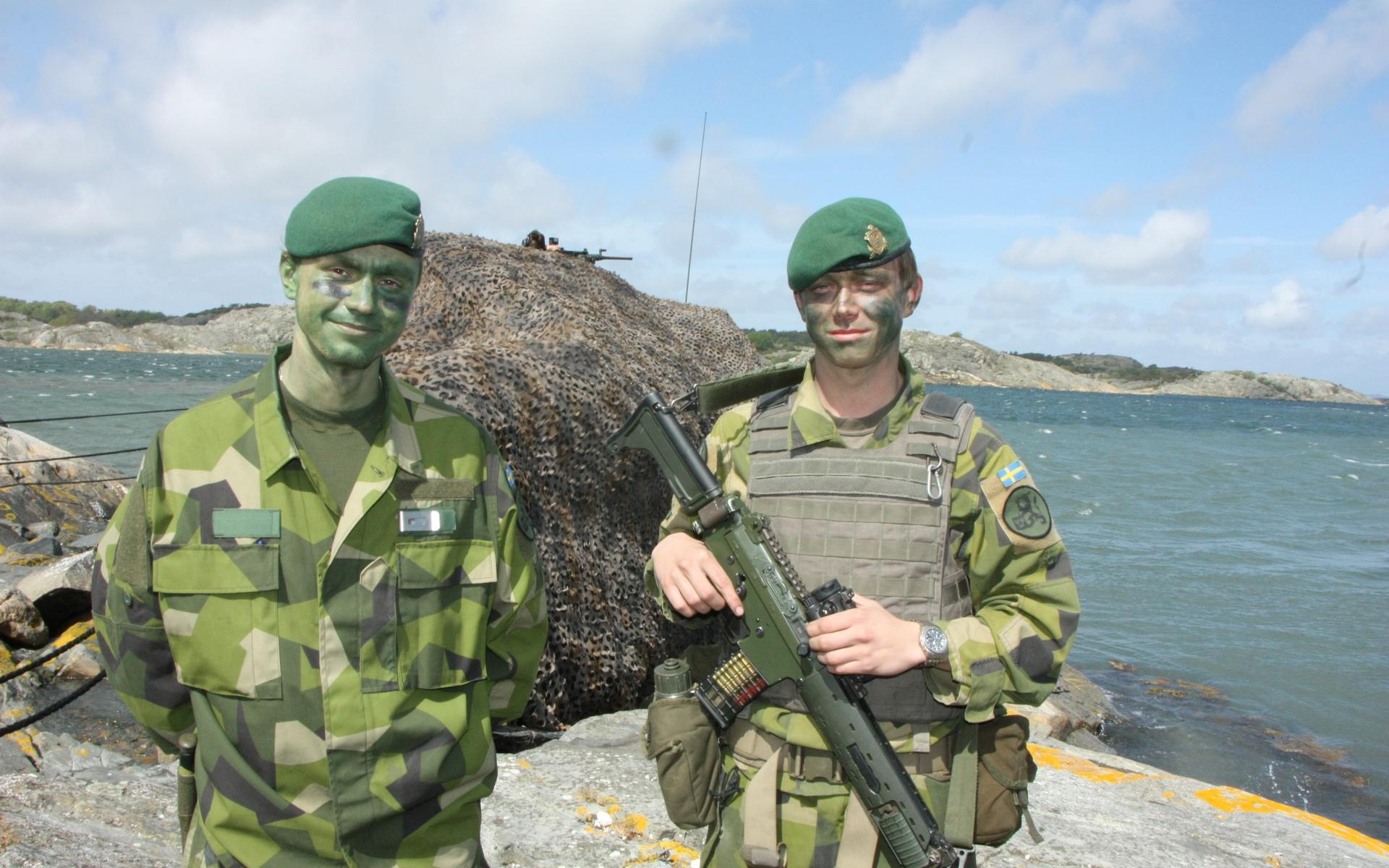 Joar Zetterfeldt från Karlstad och Elis Josefsson från Jönköping vaktar en kamoflerad stridsbåt 90. 