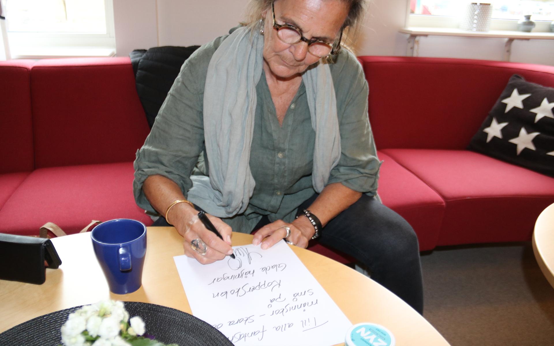 Som alla tidigare författare på besök på Kopperskolan får Moni Nilsson skriva en autograf till skolan.