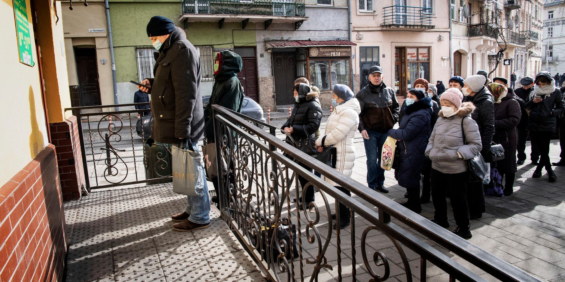 Efter att Ryssland invaderat Ukraina är det en stor oro bland befolkningen, folk köper vapen och hamstrar förnödenheter och lämnar staden för att förenas med sina familjer. Här är det kö till apoteket i Lviv, Ukrainas näst största stad.