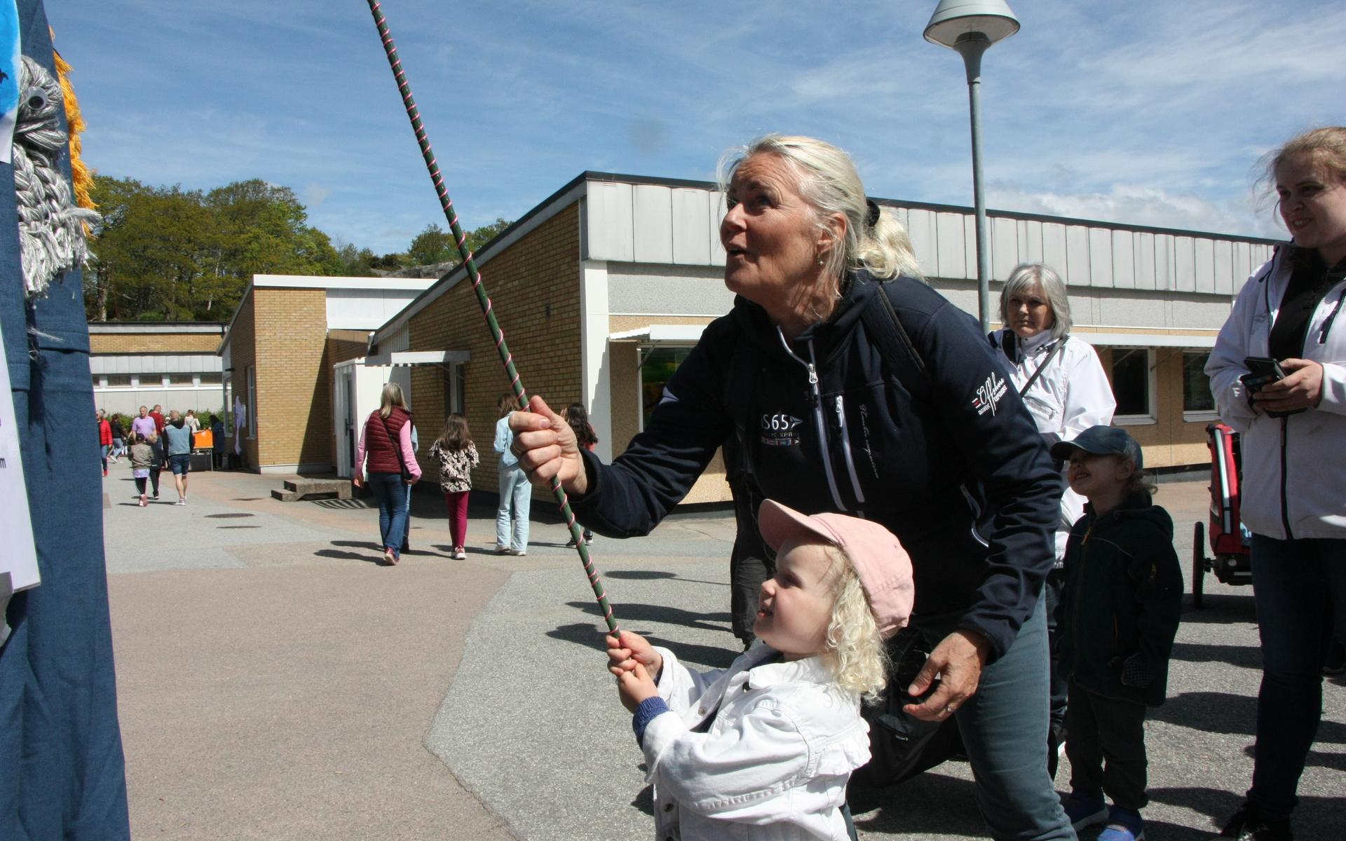 Elvira Edvardsson, 3 år, fick hjälp vid fiskdammen av Evalena Olofsson.